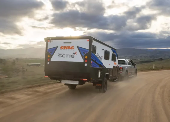 Sct16 G6 Pop Top Couples hybrid caravan driving along dusty road
